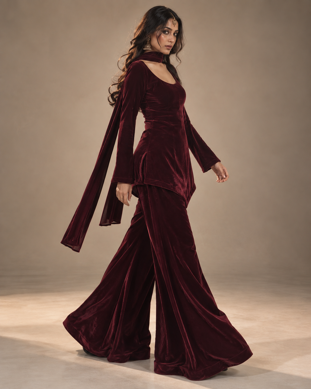 Gul deep maroon velvet sharara set walking view showing flared sharara and sleek dupatta – Kavyaantra